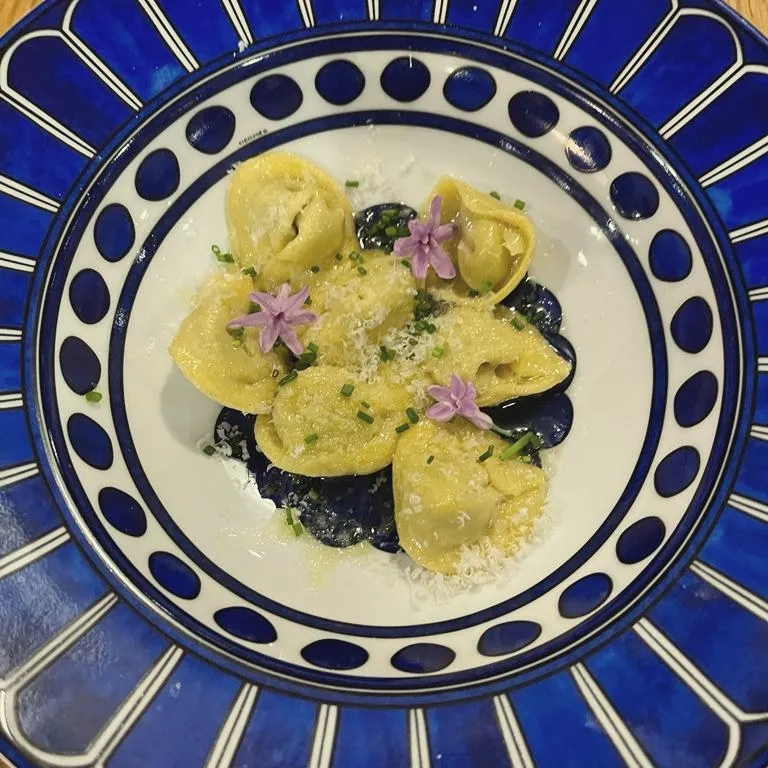 Handmade ravioli on a blue ceramic plate